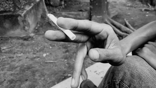 Cropped hand of man holding burnt cigarette