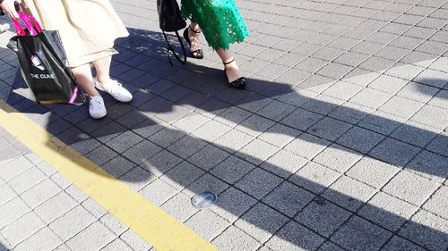 Low section of women walking on zebra crossing