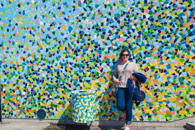 Woman standing on multi colored umbrella