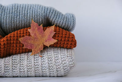 Stack of cozy knitted warm sweater with autumn fall maple leaf. sweaters in retro style. orange 