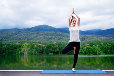 Full length of woman standing on mountain against sky