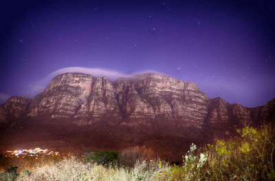 Scenic view of mountains against blue sky at night