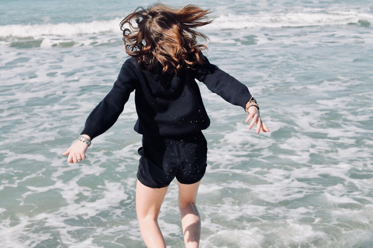 FULL LENGTH OF YOUNG WOMAN STANDING ON BEACH