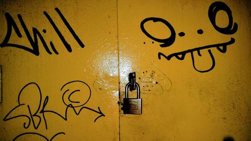 Close-up of yellow text on brick wall