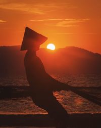 Silhouette man on beach during sunset