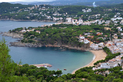 High angle view of cityscape by sea against sky