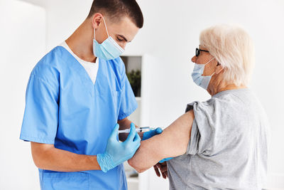 Doctor vaccinating senior patient at hospital