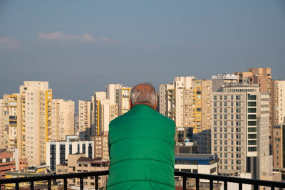 Rear view of man looking at city buildings