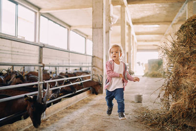 Full length of young woman standing against building