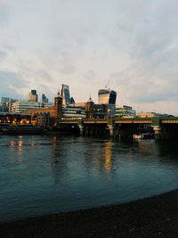 River by illuminated city against sky