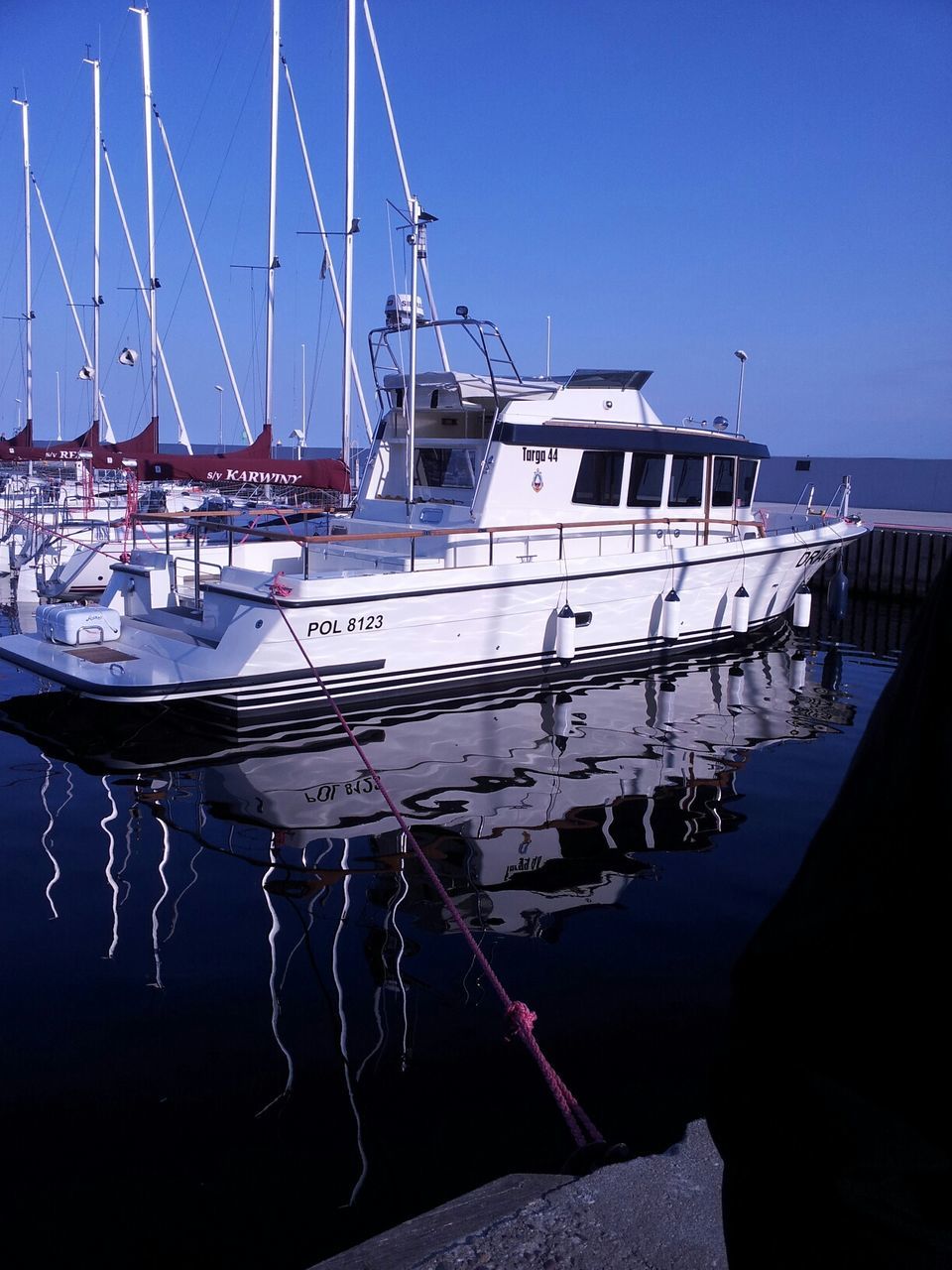 nautical vessel, boat, transportation, moored, mode of transport, water, clear sky, sea, harbor, mast, blue, sailboat, travel, copy space, day, sky, built structure, sunlight, outdoors, waterfront