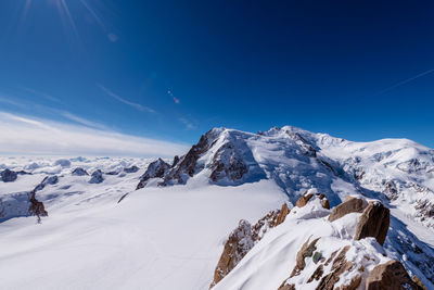 Scenic view of snowcapped mountains against blue sky