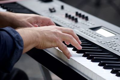 Midsection of man playing piano