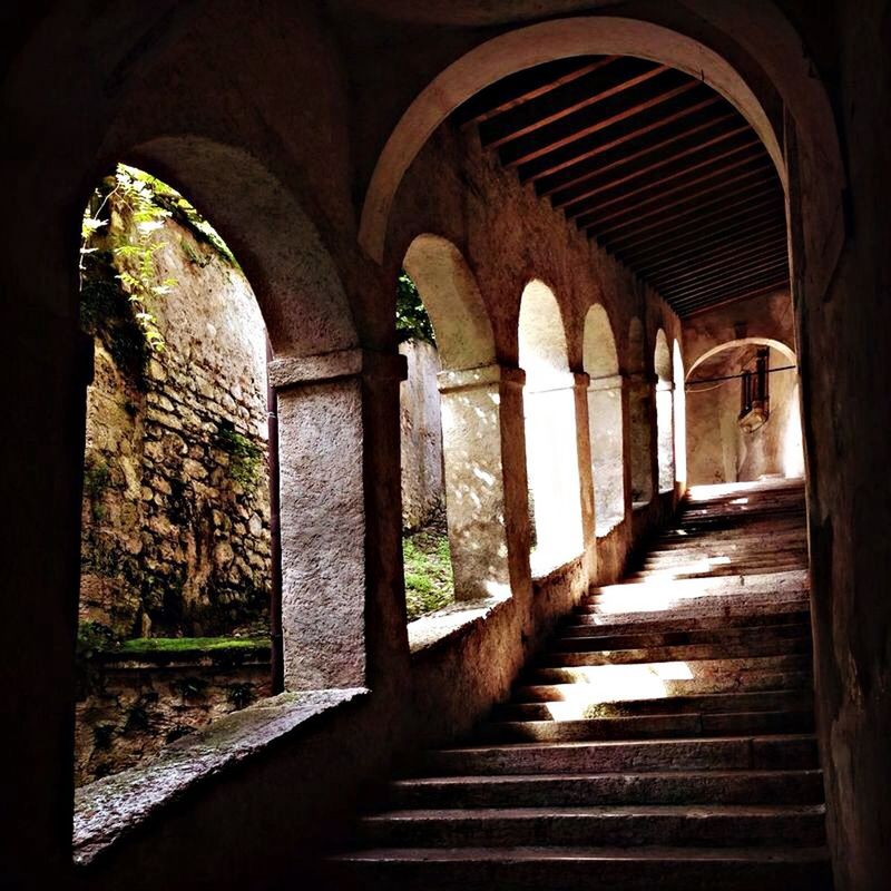 architecture, built structure, arch, indoors, the way forward, history, archway, old, architectural column, corridor, colonnade, diminishing perspective, stone wall, steps, column, building exterior, building, sunlight, wall - building feature, in a row