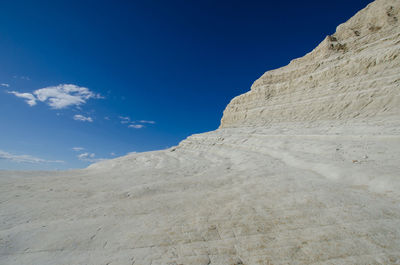 Low angle view of desert against blue sky