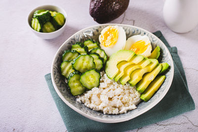 Fresh cottage cheese, avocado, cucumber and boiled egg in a plate