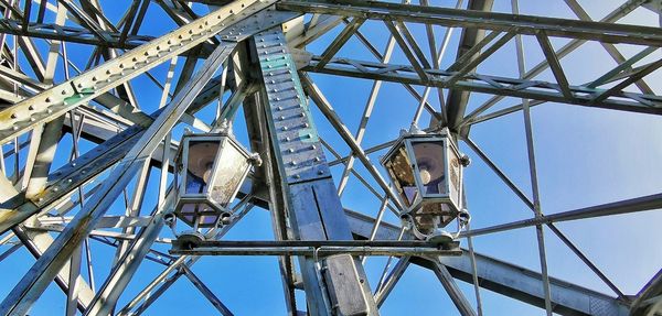 Low angle view of ferris wheel against blue sky