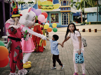 Rear view of people with balloons on street