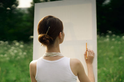 Rear view of woman standing against blurred background