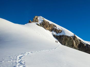 Scenic view of snowcapped mountains against clear blue sky