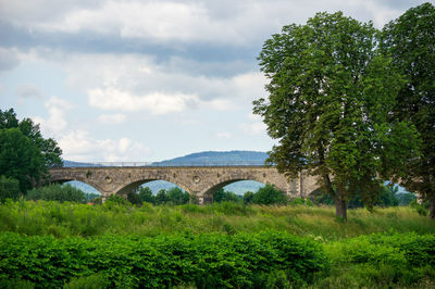Arch bridge and trees against sky