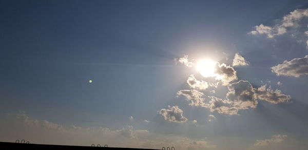 Low angle view of sun shining in sky
