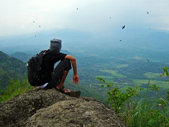 Full length of man flying over sea against mountain