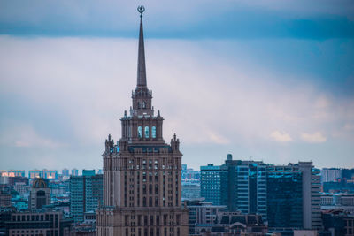 View of buildings in city against cloudy sky