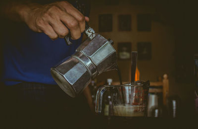 Midsection of man preparing coffee in kitchen