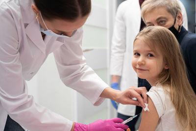 Side view of doctor examining patient at clinic