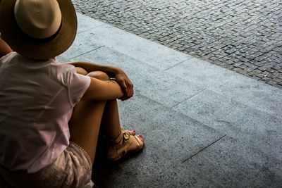 Rear view of a young man sitting on bench