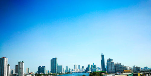Low angle view of cityscape against blue sky