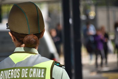 Rear view of woman in uniform standing outdoors