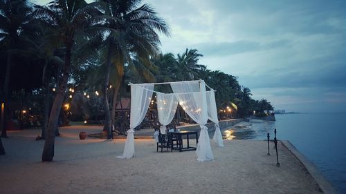 Chairs on table by swimming pool at night