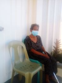 Woman sitting on chair at home