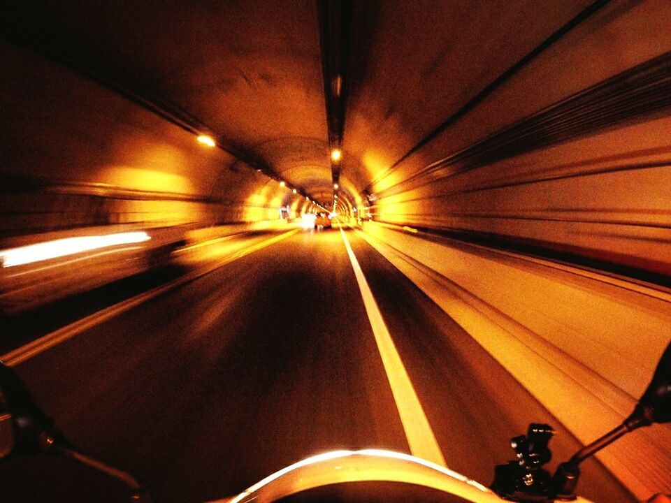 transportation, illuminated, indoors, mode of transport, tunnel, lighting equipment, diminishing perspective, the way forward, night, land vehicle, travel, vanishing point, ceiling, blurred motion, motion, on the move, light - natural phenomenon, no people, bicycle, speed