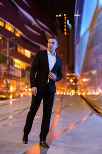 Full length of young man standing on street at night
