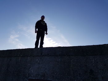 Low angle view of man standing against wall
