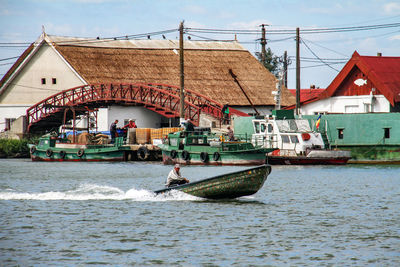 Man rowing boat on sea against sky