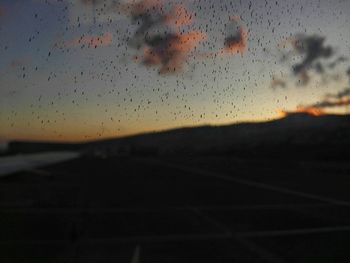 Silhouette birds flying against sky at sunset