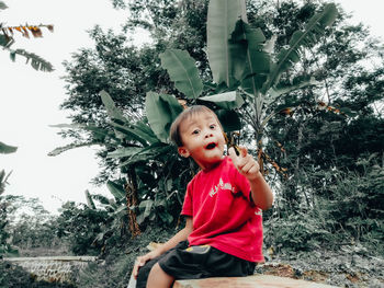 Portrait of happy boy against plants