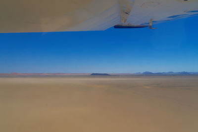 Scenic view of desert against blue sky