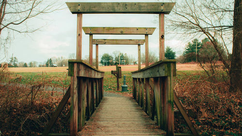 Wooden structure on field against sky