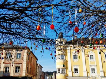 Low angle view of lanterns hanging by building against sky