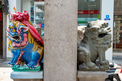 Lion statue against multi colored building