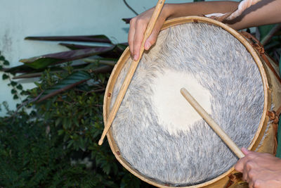 Midsection of woman playing drums
