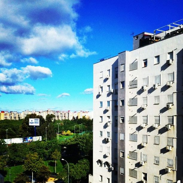 building exterior, architecture, built structure, sky, blue, city, cloud - sky, building, residential building, residential structure, window, cloud, low angle view, modern, day, outdoors, sunlight, no people, city life, office building