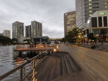 Illuminated buildings in city against sky at dusk