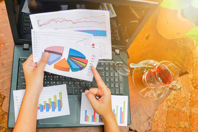 Cropped image of woman with graphs at table