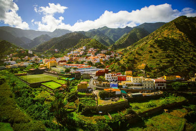 Scenic view of townscape and mountains against sky